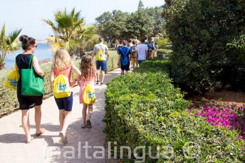 Opettaja vie oppilaita ulkoilmaan englannin tunnille.